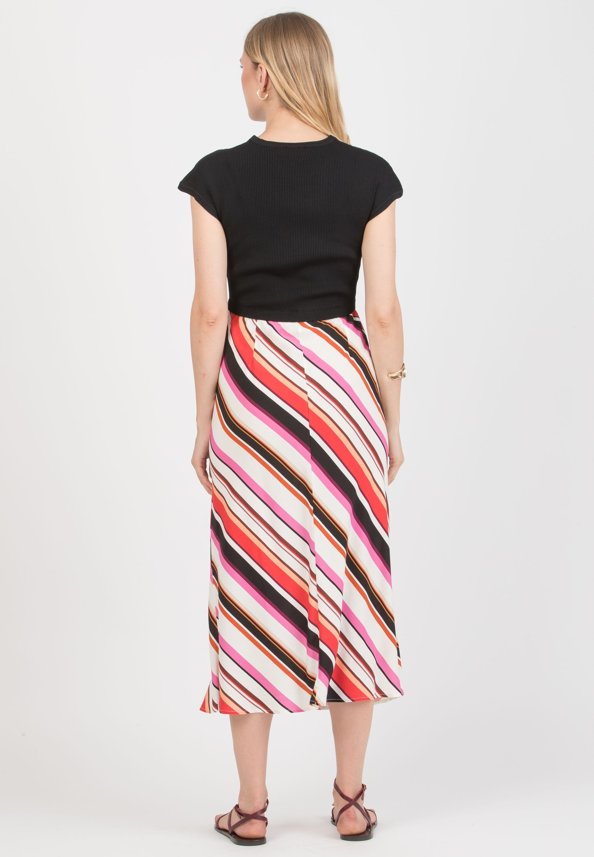 EVELIN è un abito premaman dal design contemporaneo, caratterizzato dall’abbinamento tra il corpino in maglia stretch e la gonna in viscosa tagliata in sbieco. La parte superiore, con scollo a V e linea pulita, offre una vestibilità aderente ma confortevole, seguendo naturalmente le forme. La gonna fluida in viscosa, con taglio sbieco, valorizza il movimento e dona leggerezza alla figura, creando una silhouette armoniosa e slanciata. Il mix di materiali e il gioco di contrasti rendono questo modello versatile e adatto sia al quotidiano che a occasioni più ricercate. (Nero)